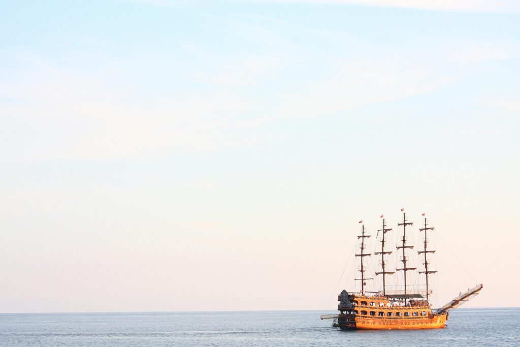 A majestic pirate ship sails the calm waters at sunset in Alanya, Turkey.